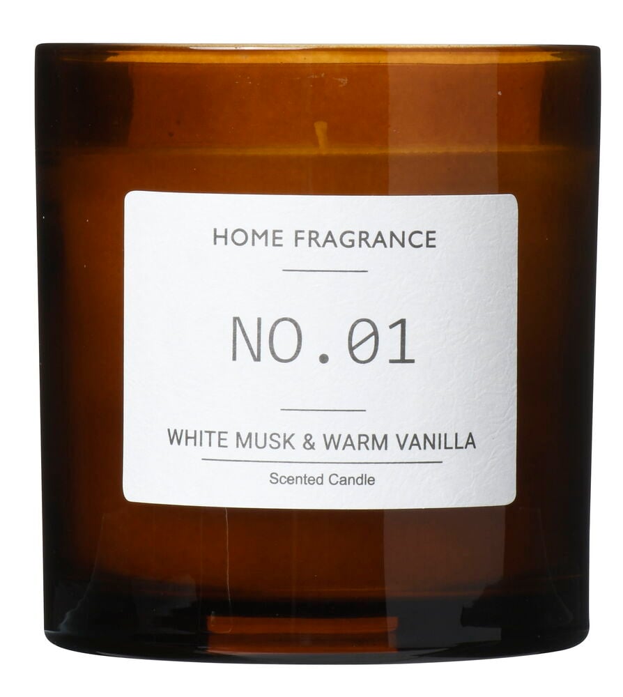 Brunt doftljus i glasbehållare med vit etikett.