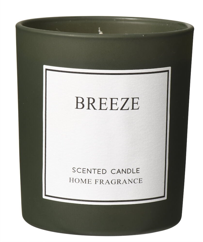 Grønt duftlys i glass med hvit etikett.