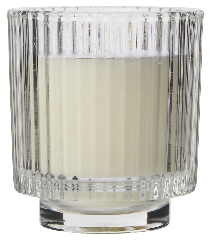 Vitt doftljus i räfflad glasbehållare.