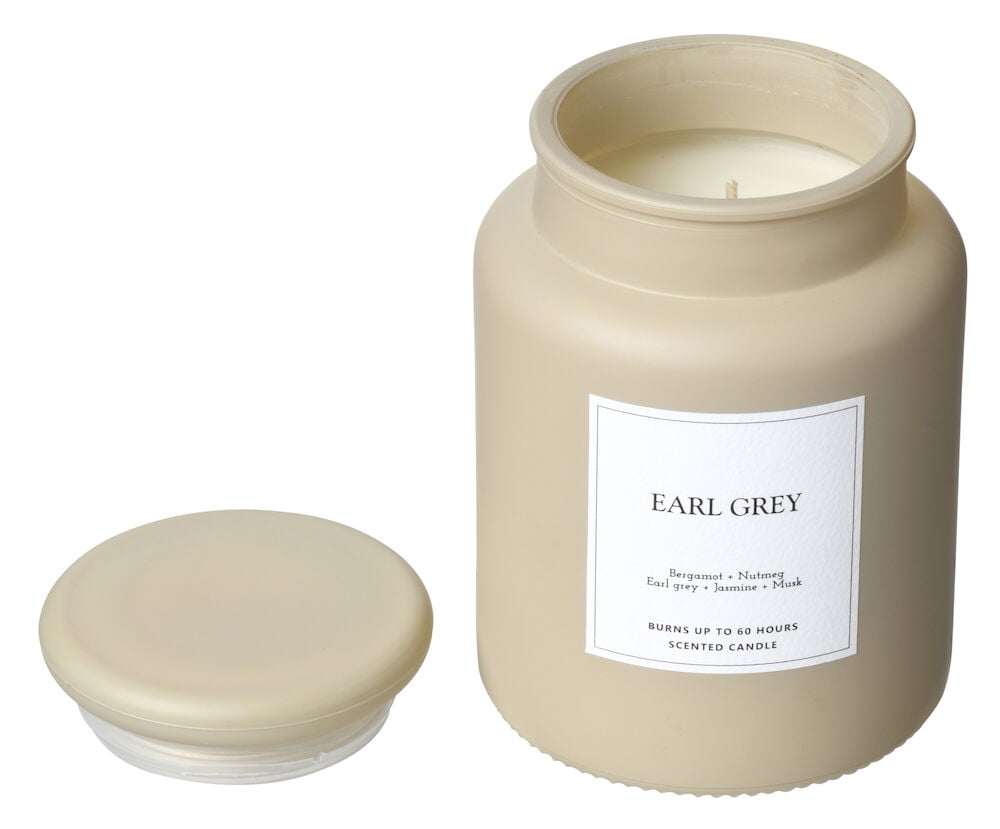 Beige doftljus i glasburk med löst lock.