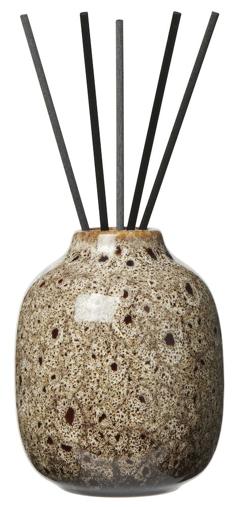 Brunmelert keramikkbeholder med fem svarte duftpinner.