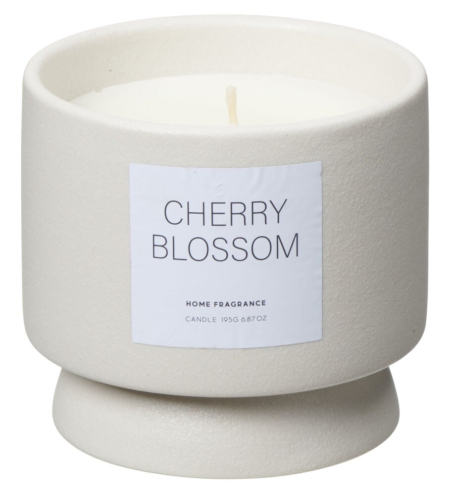 Vitt doftljus i rund keramikkopp med etikett.