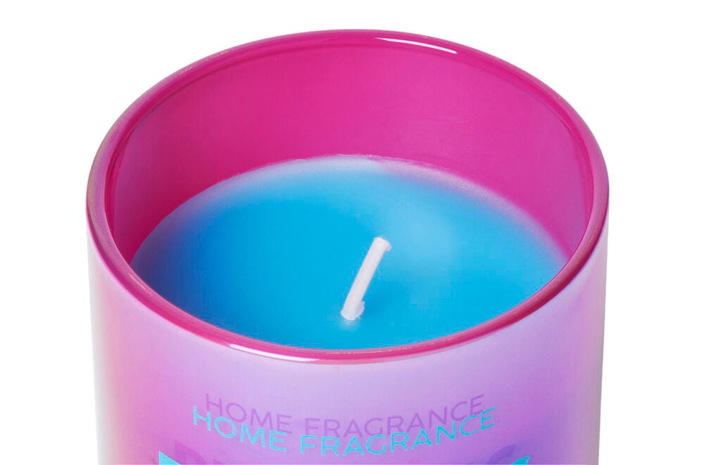Blaue Duftkerze in rosa Glasbehälter.