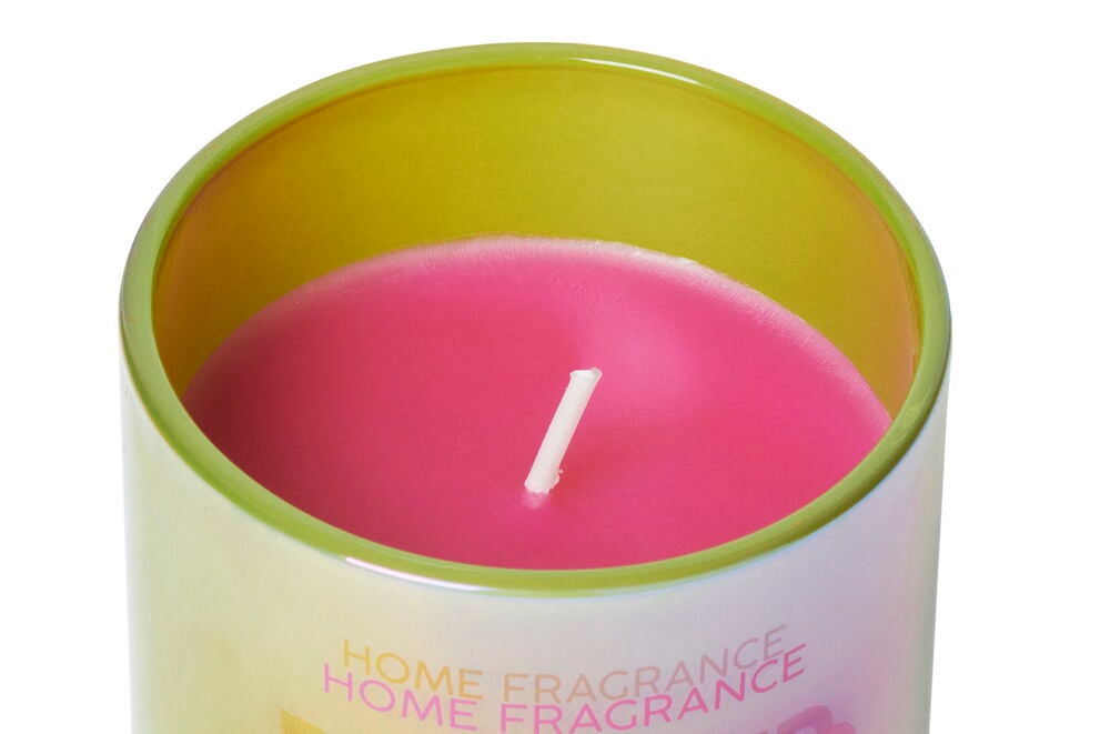 Rosa Duftkerze in einem grünen Glasbehälter.