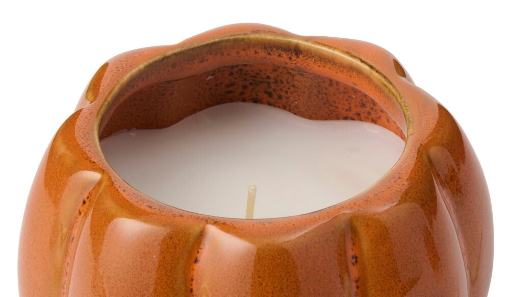 Närbild uppifrån på ett orange glaserat Doftljus keramik Pumpkin med ett vitt ljus och veke inuti.