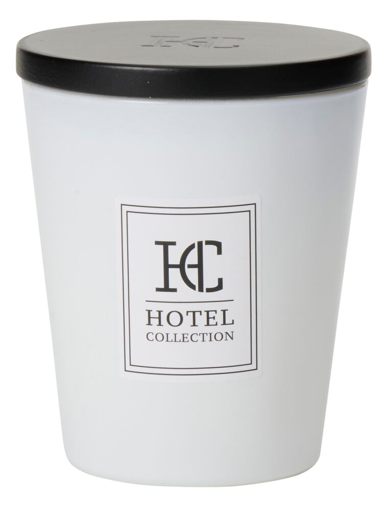 Vit doftljusburk med svart lock och etikett.