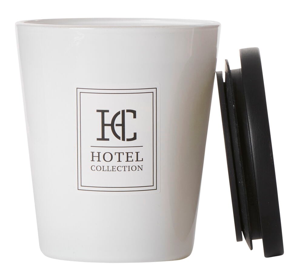 Vitt doftljus i glas med svart lock.