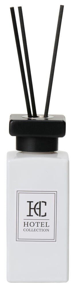 Hvit firkantet flaske med svarte duftpinner.