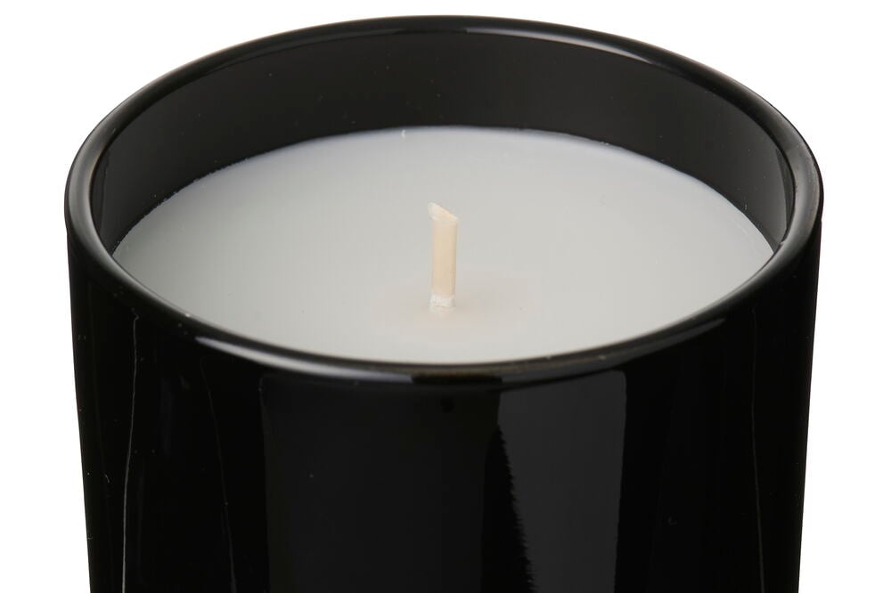 Nærbilde ovenfra av et svart Glass Incense Oud-lys med hvit voks og en sentral veke.