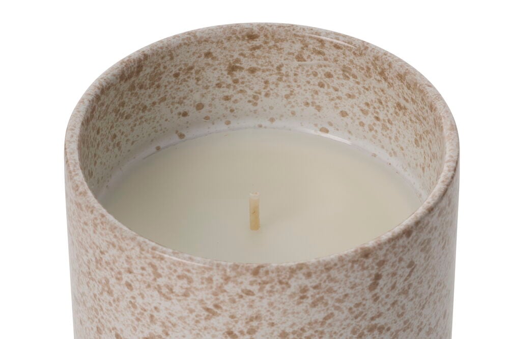 Nærbilde av et Duftlys Deer i en rund, flekket beige keramikkrukke med hvitt lys og synlig veke.