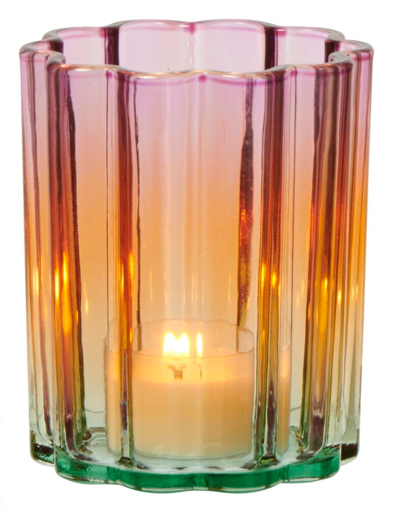 Monivärinen lasinen kynttilänpidike, jossa sisällä palava tuikkukynttilä.
