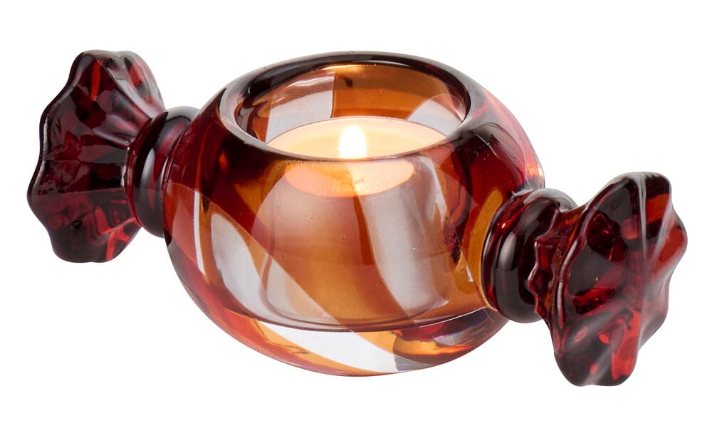 Telysholder Sweetie Glass, formet som en godteri med røde og oransje virvler, holder et tent telys.