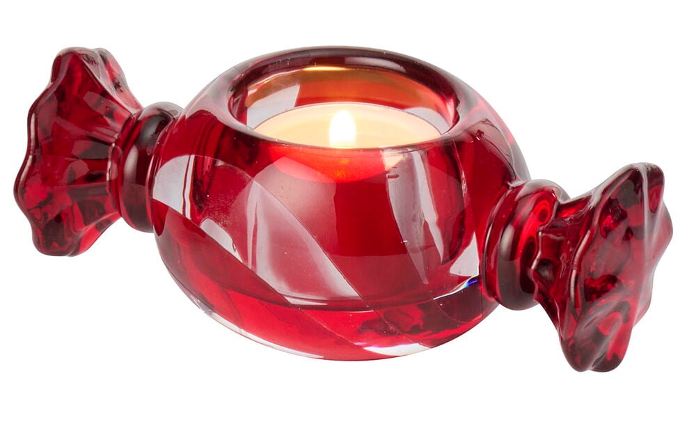 En rød Telysholder Sweetie Glass, formet som et godteri, med et tent lys.