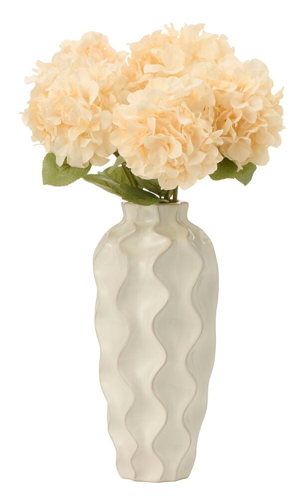Kerma Hortensia 59 cm tekokukat ja vihreät lehdet, aseteltuna korkeaan, kermanväriseen keraamiseen maljakkoon aaltokuviolla.