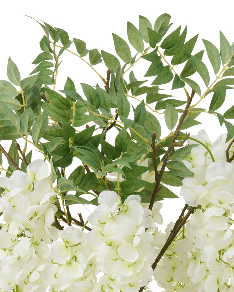 Närbild av en Blåregn 75 cm Vit konstgjord blomma med vita blommor och gröna blad.