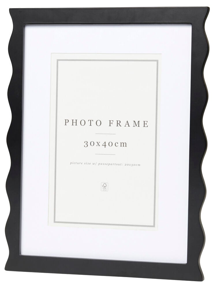 Svart ram med vågig kant och vit passepartout.