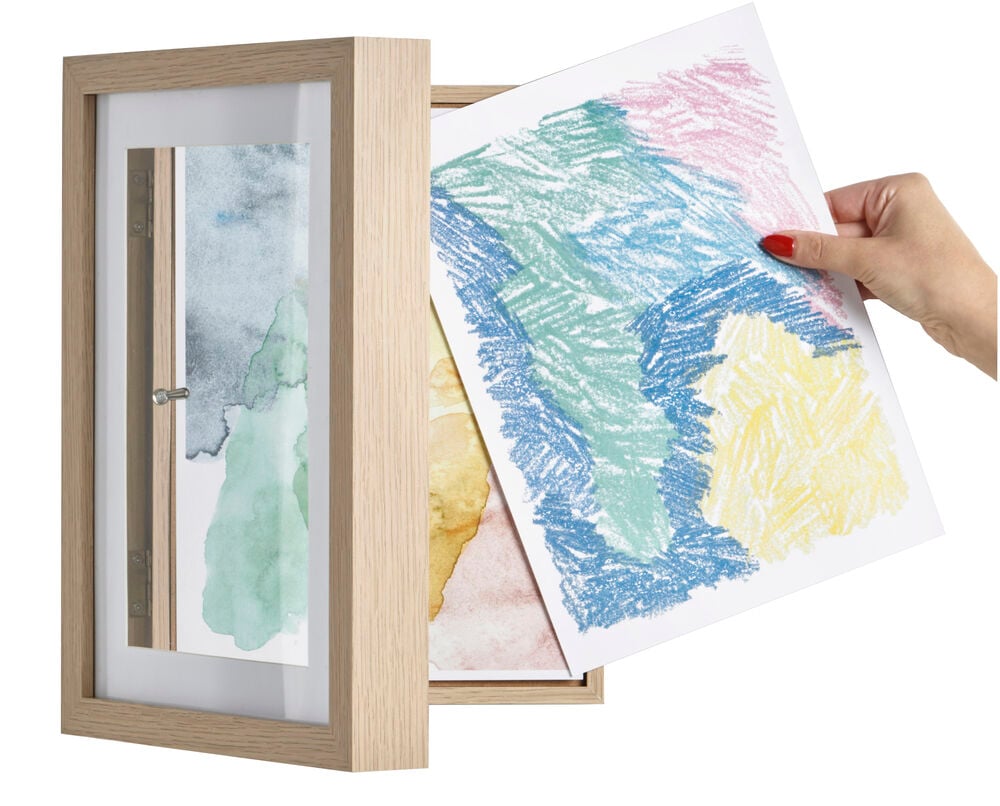 Puukehys, jossa on piirustusten säilytys ja lasten taideteokset näkyvissä.