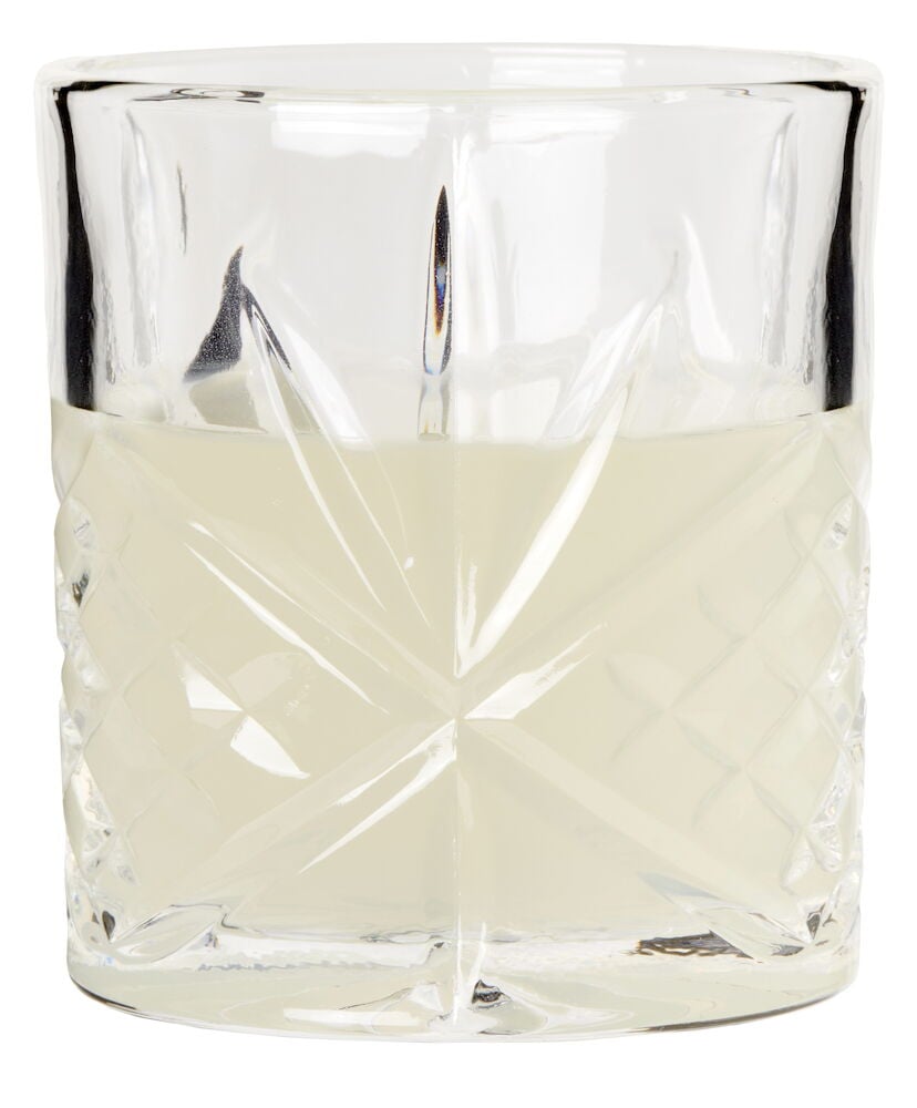 Klassiskt glas med diamantmönster fyllt med ljus dryck.