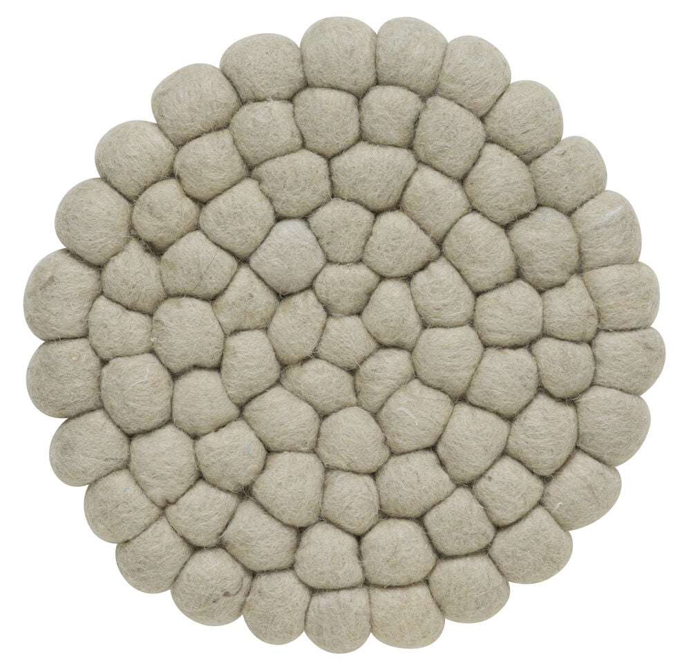 Rundt grytunderlägg av beige ull.
