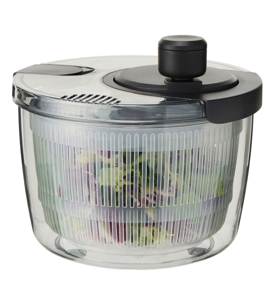 Transparent salladsslunga med vitt lock och grönsaker.