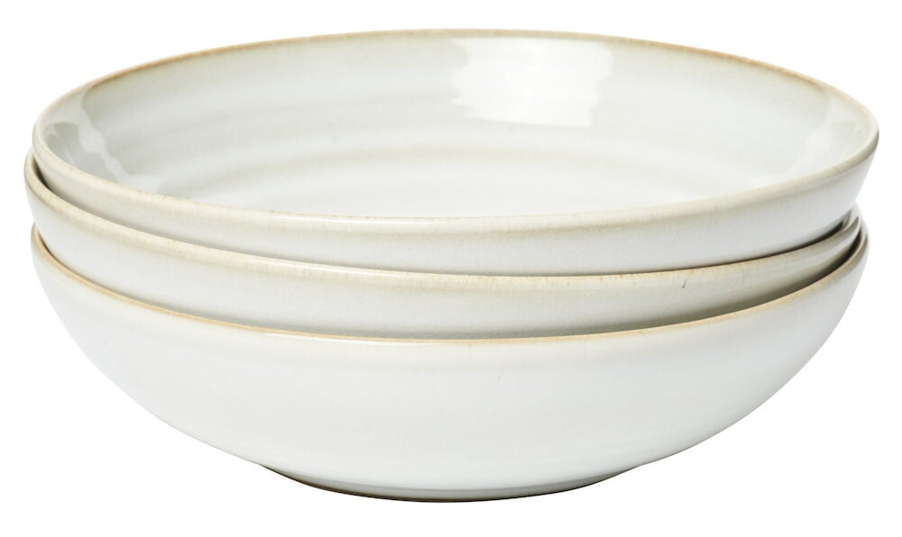 Kolme päällekkäin pinottua syvää valkoista kivitavaralautasta.