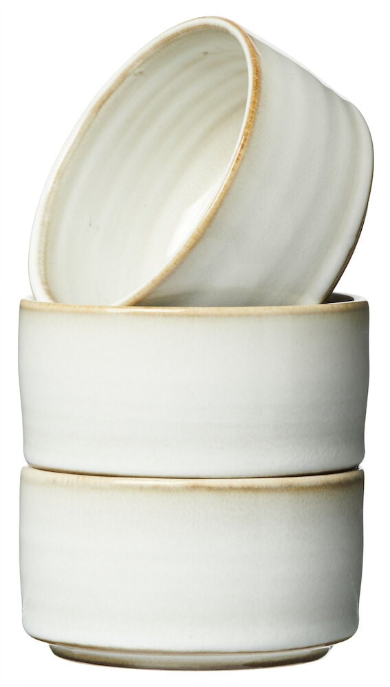 Kolme pientä valkoista kivikeraamista kulhoa pinottu päällekkäin.