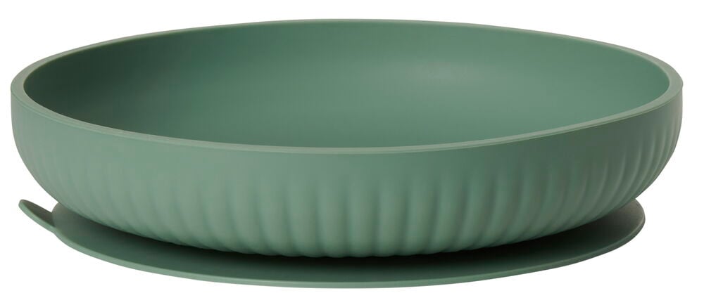 Vihreä lasten silikonilautanen, jossa on imutoiminto alustaa vasten.