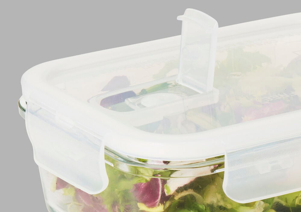 Matlåda i glas med plastlock och grönsaker.