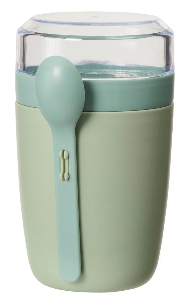 Vihreä jogurttimuki lusikalla ja läpinäkyvällä kannella.