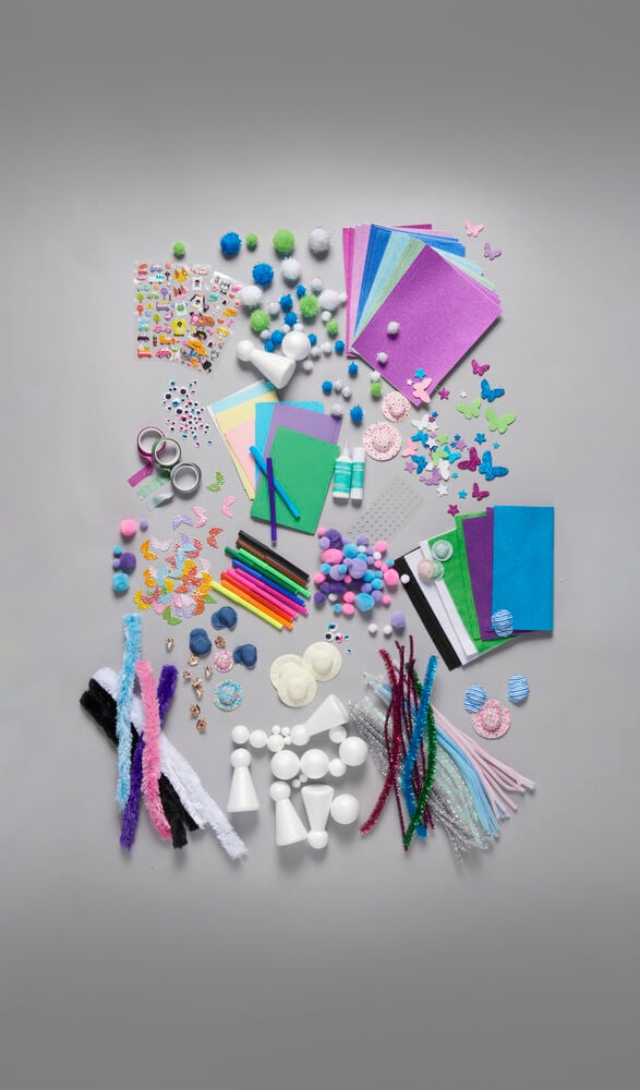 Flera pysselmaterial som papper, garn, glitter och klistermärken.