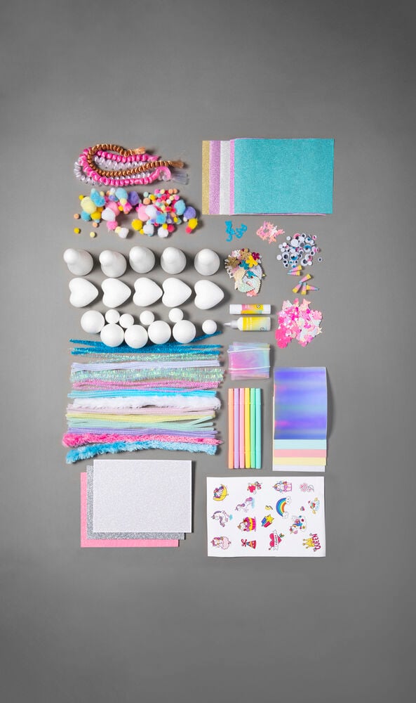 Sorterade pysselmaterial i pastellfärger på grå bakgrund.