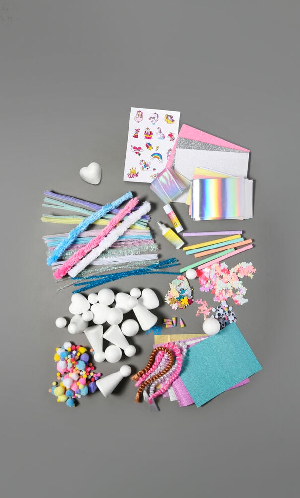 Färgglatt pysselset med papper, pennor och dekorationer.