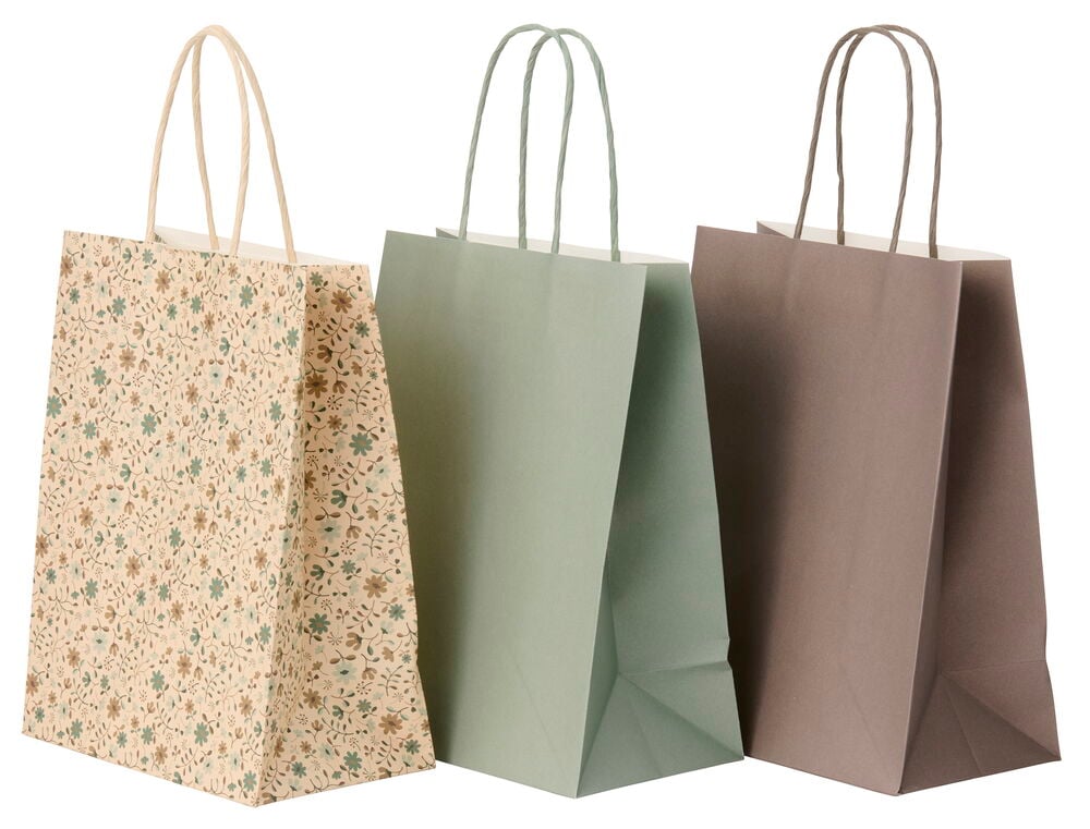 Beige kukallinen lahjakassi kierretyillä kahvoilla, sekä yksi yksivärinen vihreä ja yksi ruskea lahjakassi.