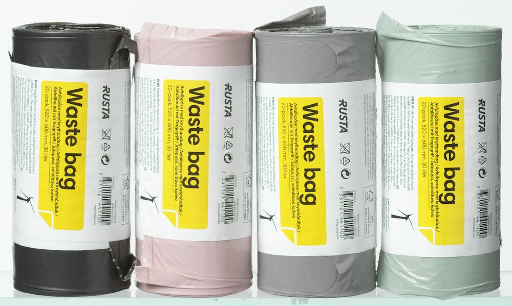 Neljä rullaa jätepusseja eri väreissä.