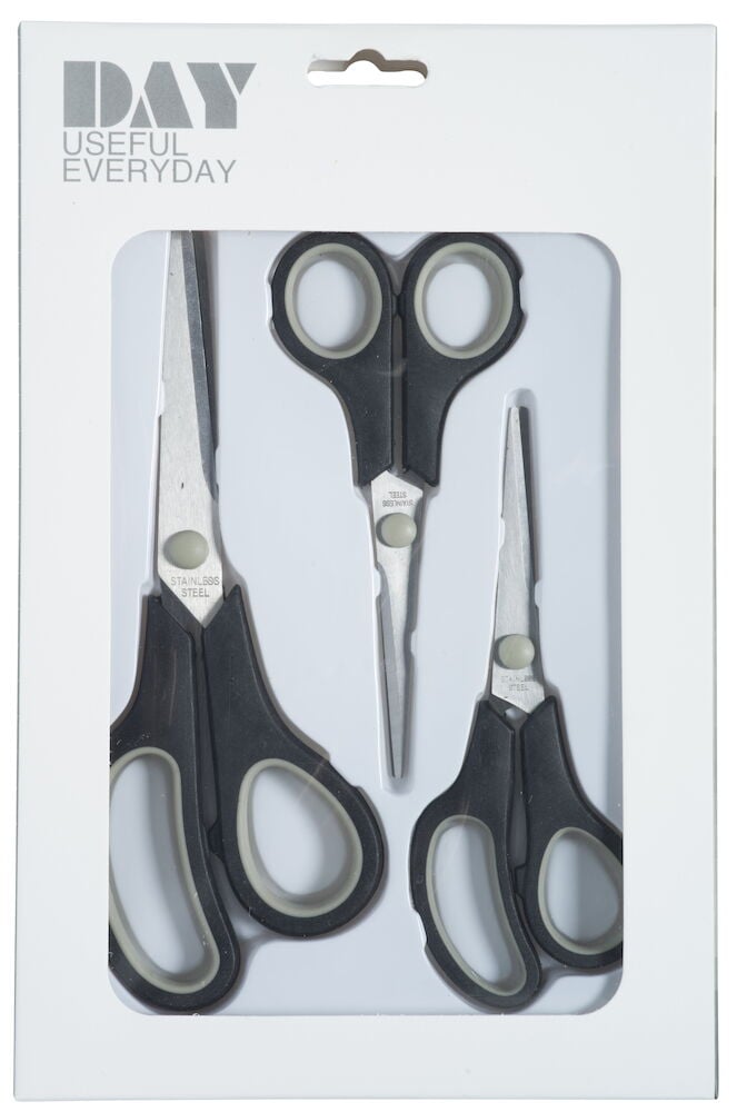 Kolme mustaa saksia läpinäkyvässä pakkauksessa.