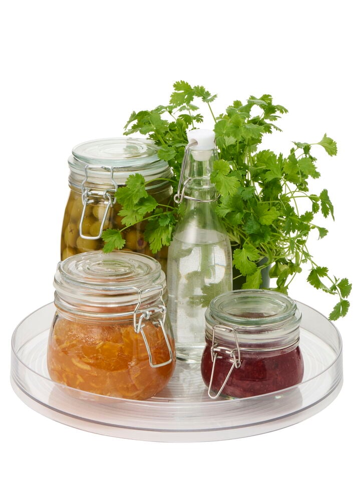 Klare, runde Drehplatte mit drei Glasgefäßen und einer Glasflasche mit Bügelverschluss.