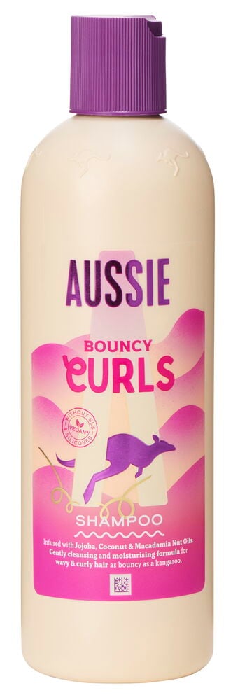 Beige shampoopullo, jossa violetti korkki ja teksti.