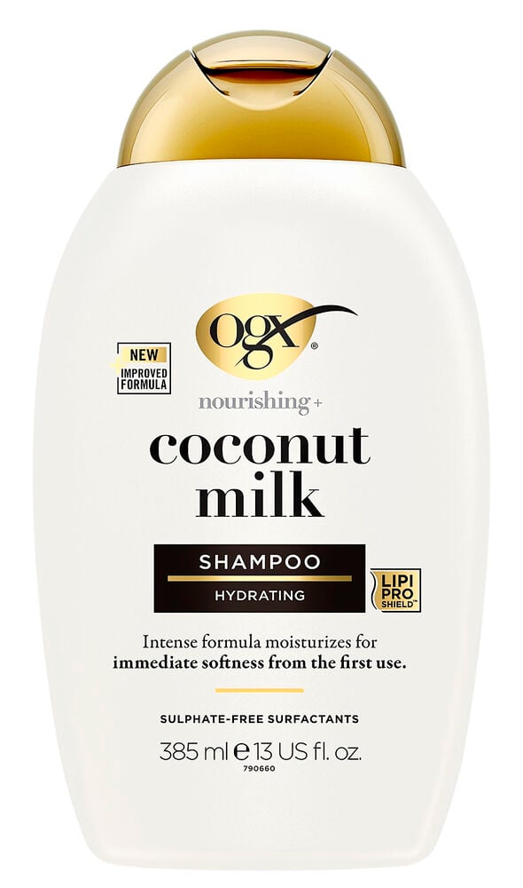 Vit schampoflaska med guldkork och svart text.