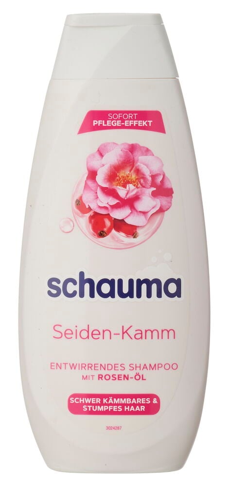 Eine weiße Schauma Seiden-Kamm Shampoo-Flasche mit einer rosa Rose und roten Hagebutten auf dem Etikett.