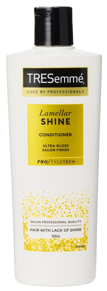 Vit flaska Tresemmé balsam med svart lock.