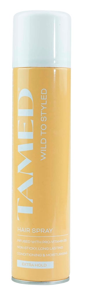 Eine hellgelbe/orange Haarspray Tamed 300 ml Dose mit weißer Kappe, beschriftet mit 'EXTRA HOLD'.