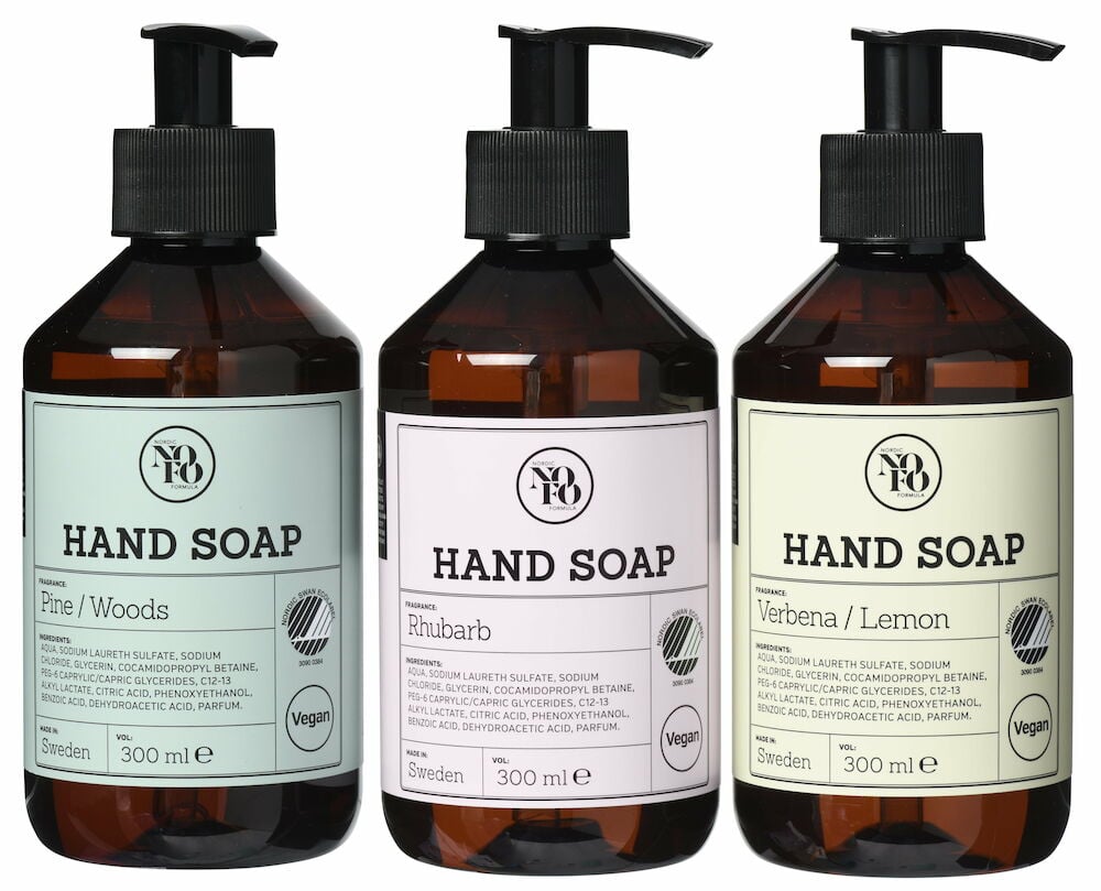 Tre bruna plastflaskor med pump, etiketter i pastellfärger.