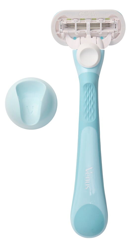 Lyseblå Gillette Venus barberhøvel med hvitt hode og tre blader, samt et lyseblått stativ.