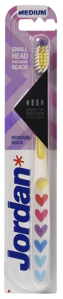 Hammasharja pakkauksessa, jossa on värikkäitä sydänkuvioita.