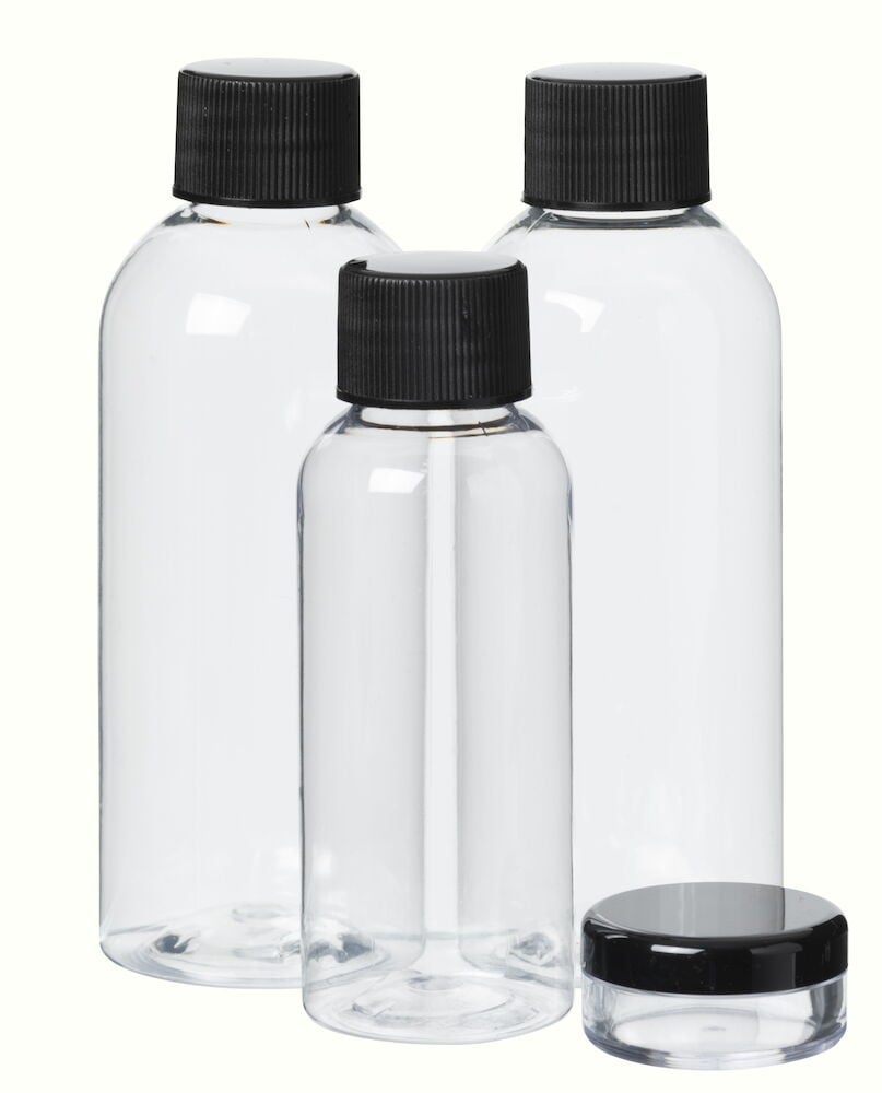 Fyra tomma reseflaskor med svarta lock.