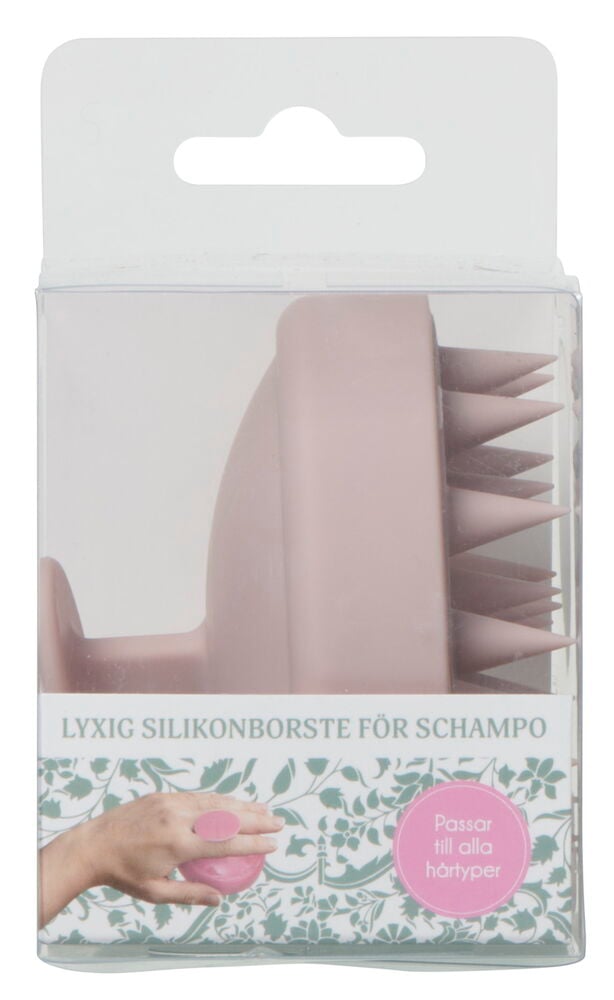 Rosa silikonborste för schampo i genomskinlig förpackning.