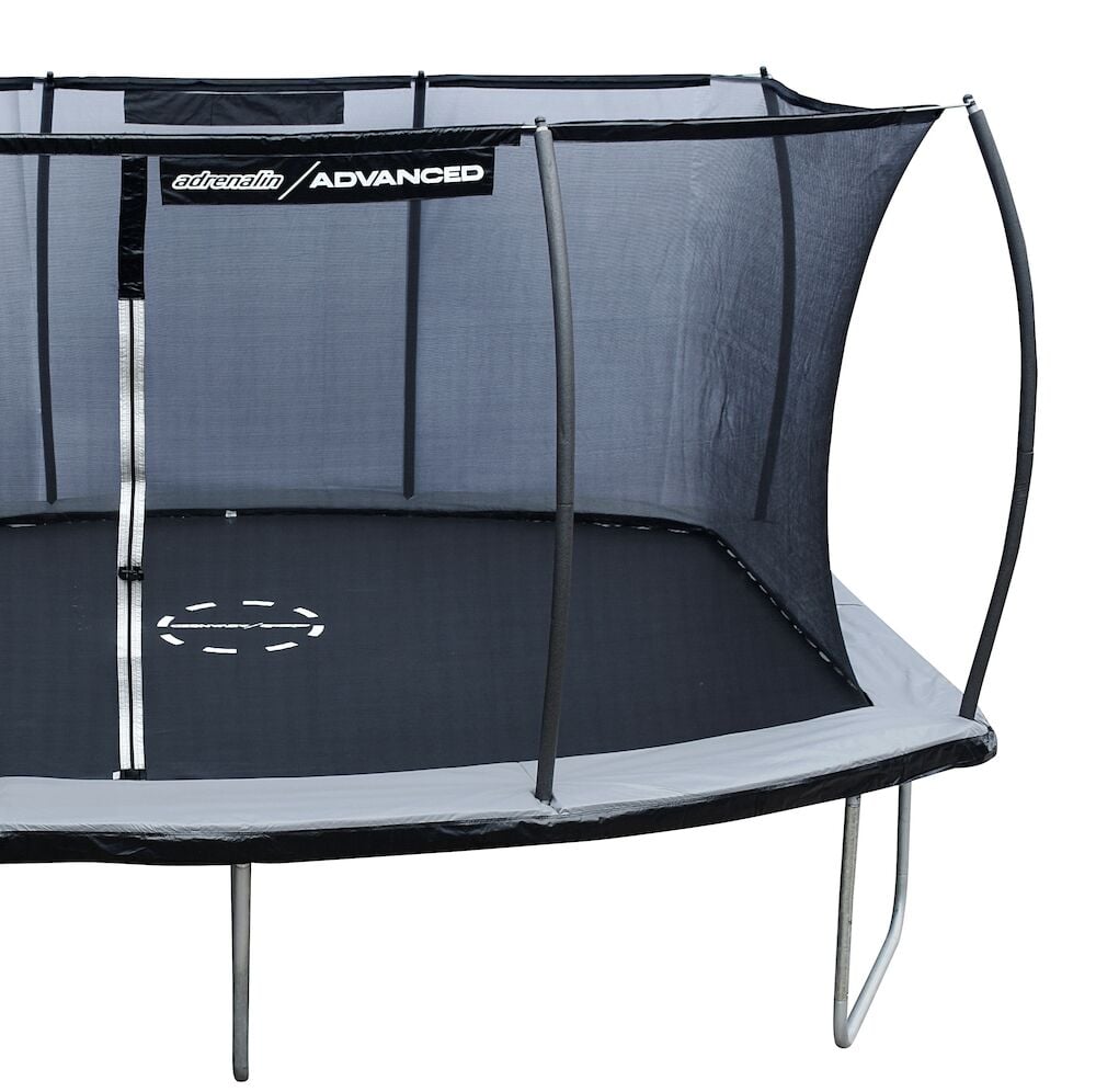 Pyöreä trampoliini mustalla turvaverkolla ja harmaalla reunasuojalla.