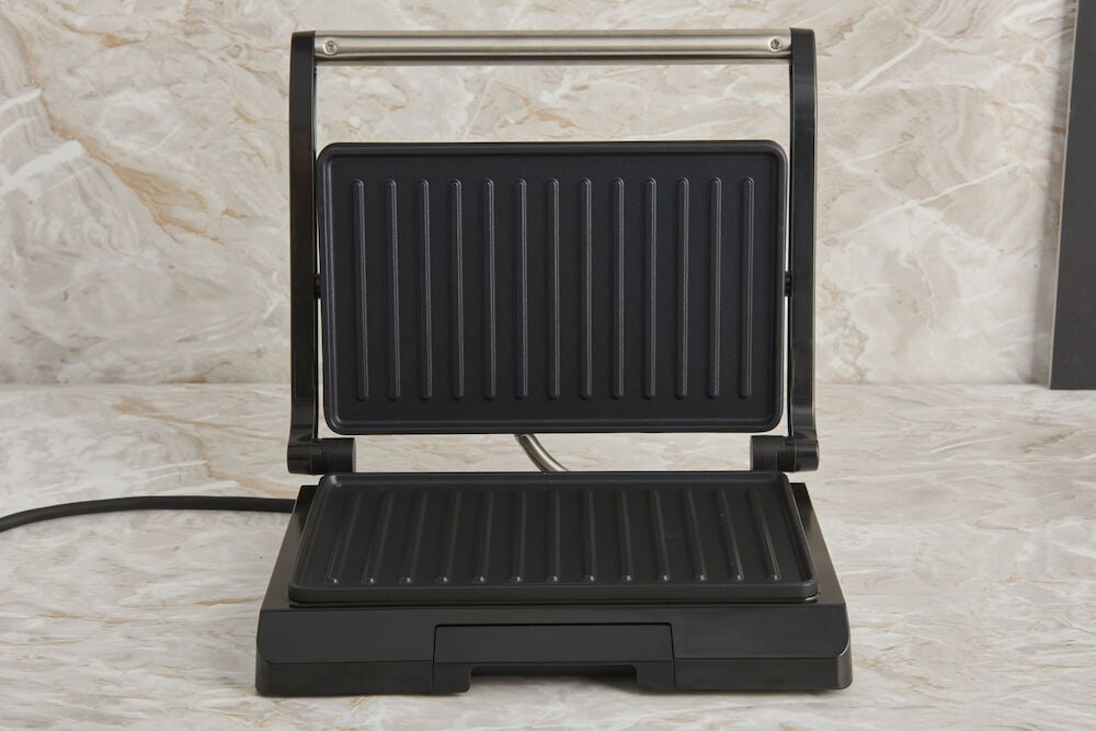 Musta monigrilli tippalevyllä marmoritasolla.