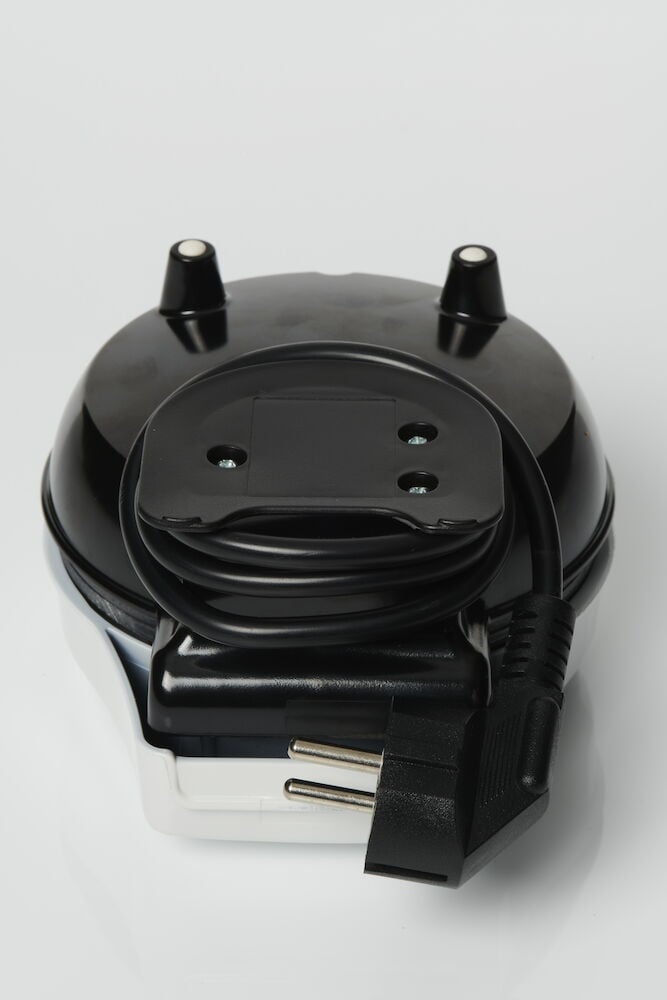 Svart våffeljärn med sladd och stickkontakt synlig.