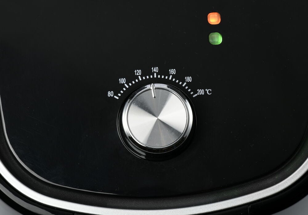 Närbild av temperaturvred på svart airfryer.